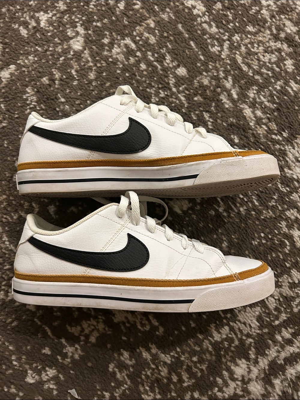 Nike White Sneakers with Black Swoosh and Gold Accent